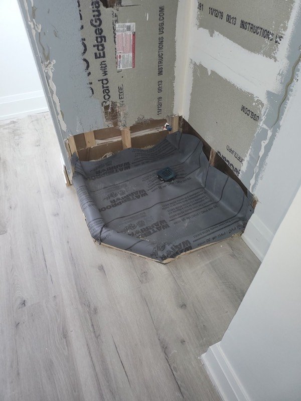 Corner shower base set and waterproofed against cement board, ready for tile